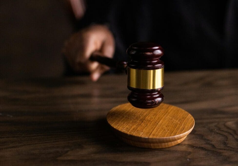 A judge 's gavel on top of a wooden table.